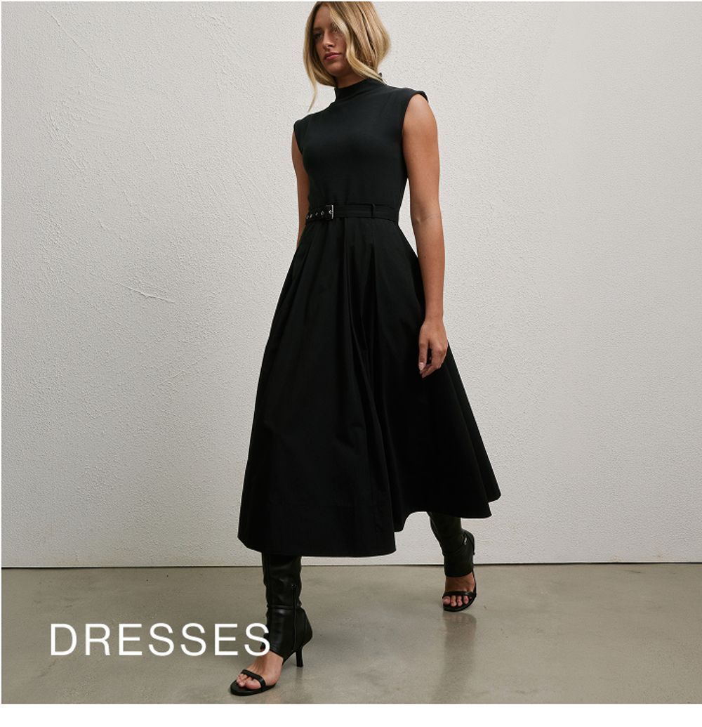 Woman standing in front of a white wall with text that reads "25% off jackets"