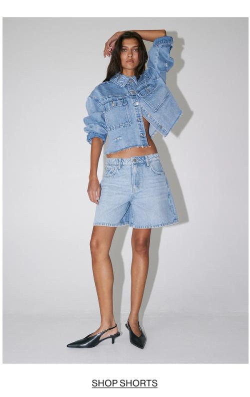 Woman posing in double denim shorts with text overlay shop shorts