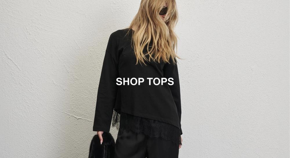 Woman standing in front of a white wall wearing a blue long sleeve shirt with text overlay which states "20% off Tops"