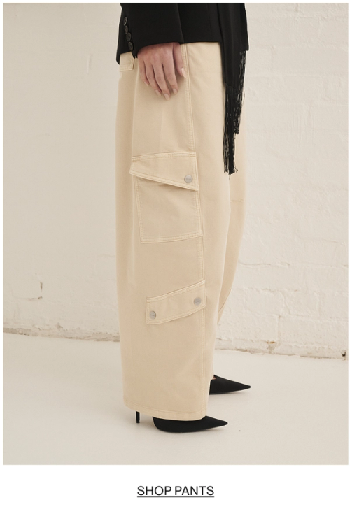 Woman posing in almond colour pants with text overlay shop pants