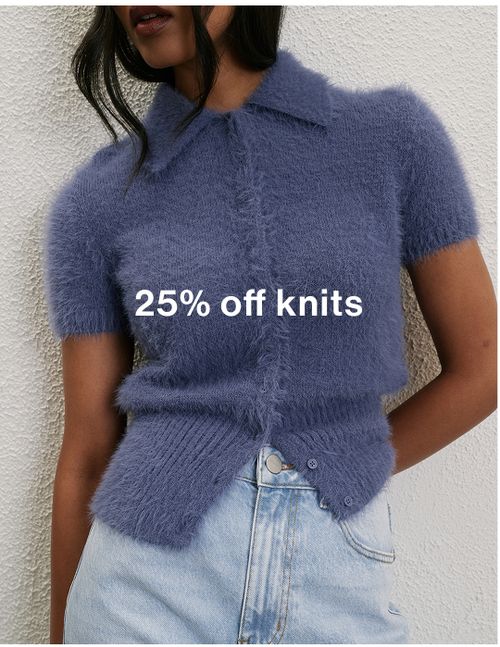 Woman standing in front of a white wall with text that reads "25% off jackets"