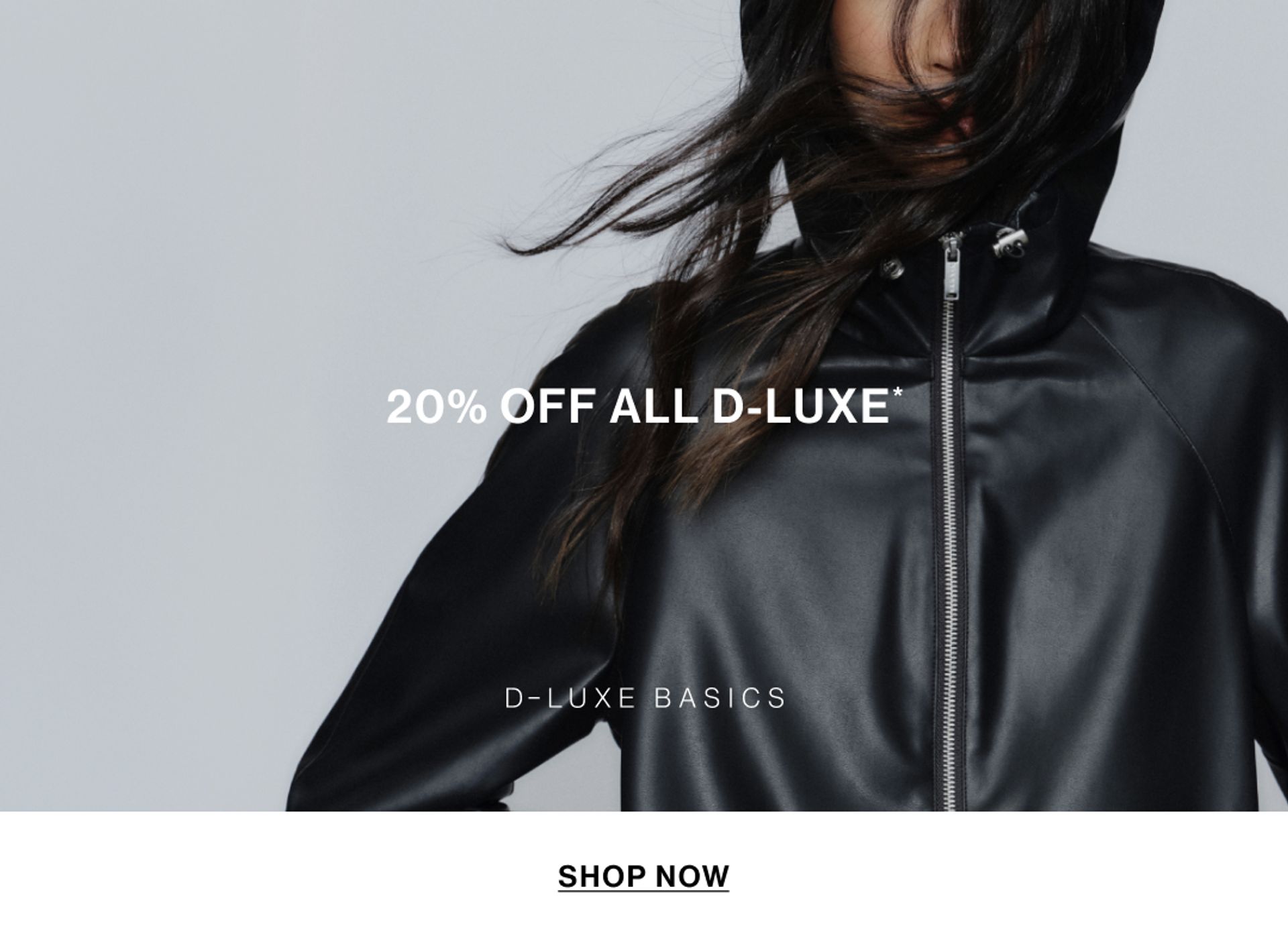Model in a leather jacket standing in front of a white wall with text overlay which states "20% OFF DLUXE BASICS"