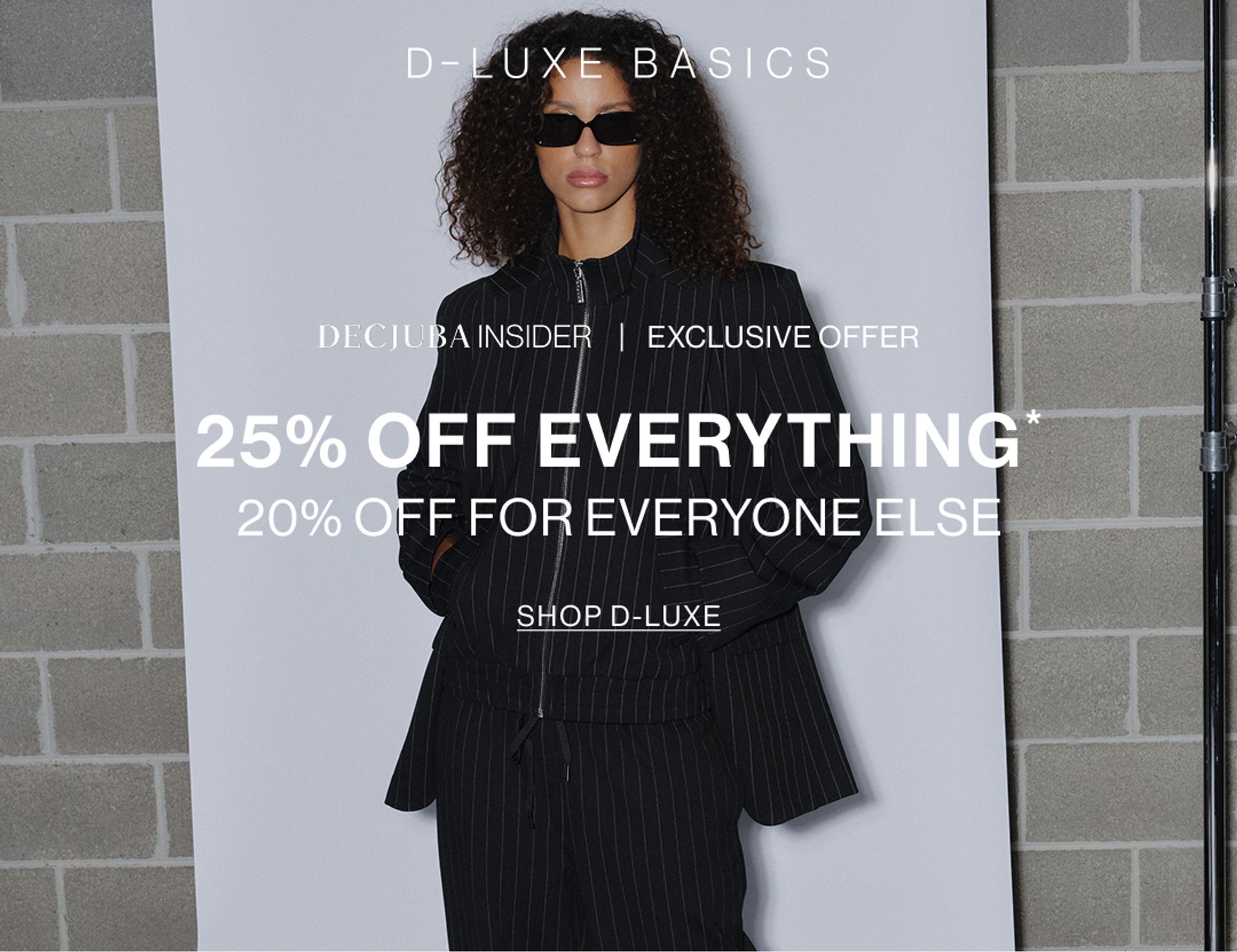 Model in a brown jacket standing in front of a white wall with text overlay which states new