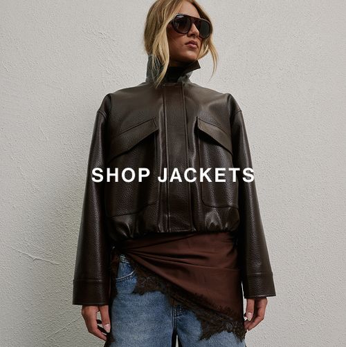 Woman posing in front of a white wall wearing brown leather jacket and sunglasses with text overlay that says "SHOP JACKETS"