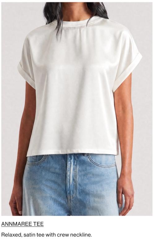 Woman standing in front of a white wall wearing a white shirt and light denim jeans, with overlaid text that reads “Shop Paloma”