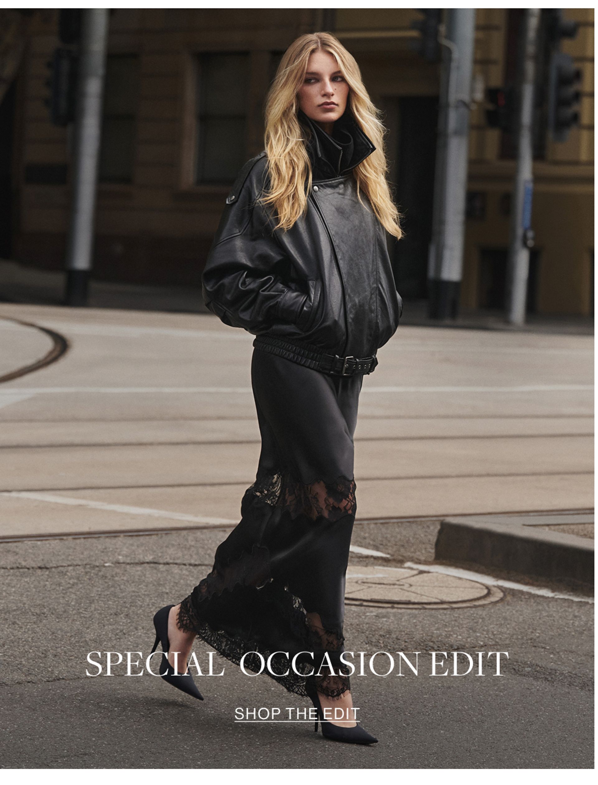 Woman walking across the road wearing a leather jacket and black skirt with text overlay that states "special occasion edit"