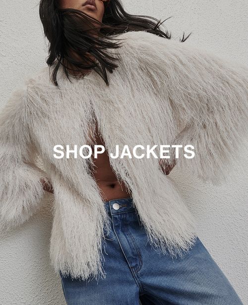 Woman posing in front of a white wall wearing a jeans and a black long sleeve top with text that states "20% off all denim"