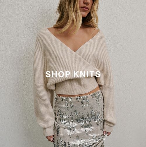 Woman posing in front of a white wall wearing a cream knit and sequin skirt with text overlay that says "SHOP KNITS"
