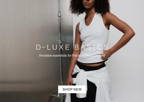 Model in a white tank, standing casually against a metal wall with one hand in her pocket. Text reads ‘DLUXE basics: the latest essentials for this season and beyond.