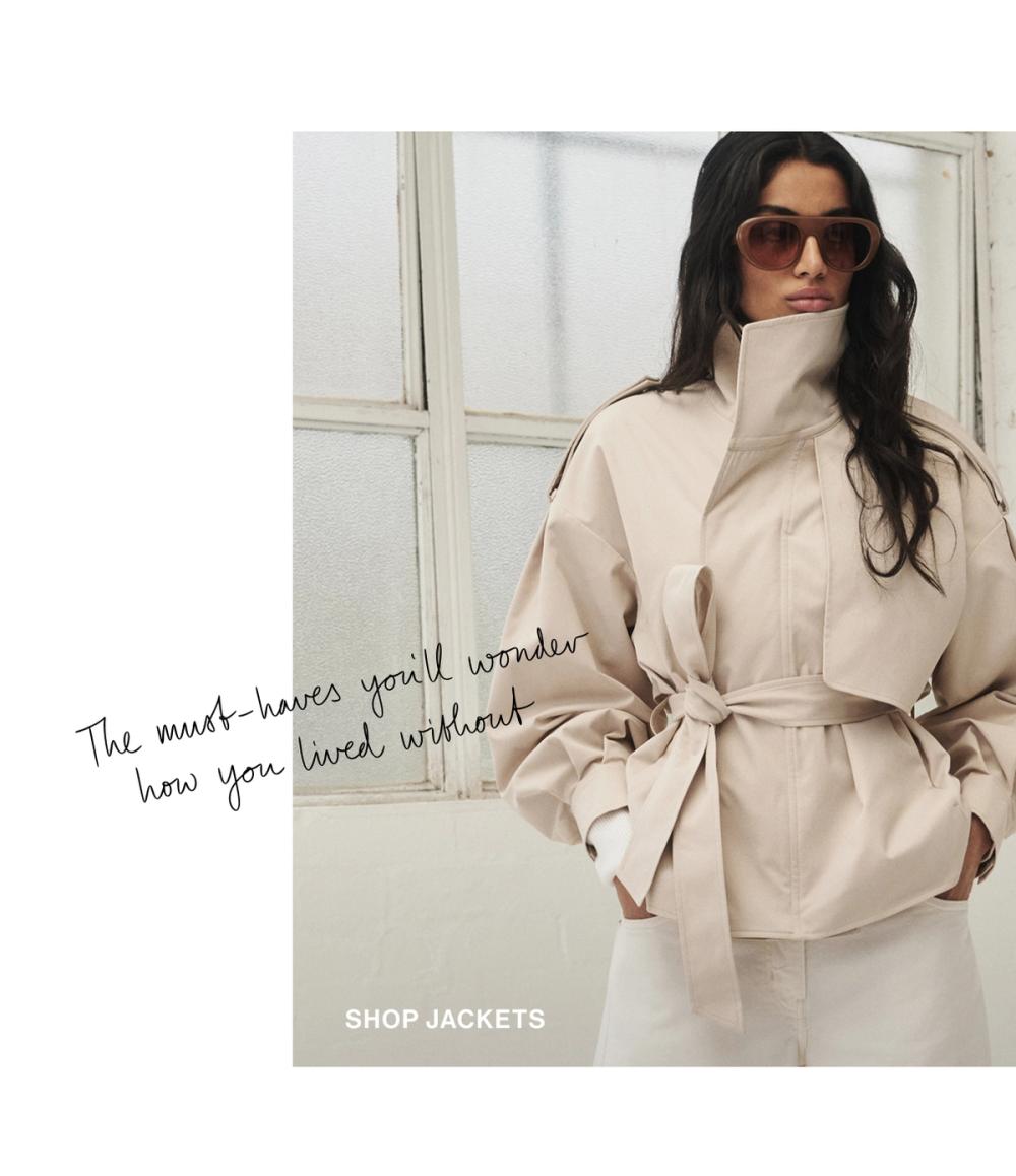 Woman standing in a cream trench jacket