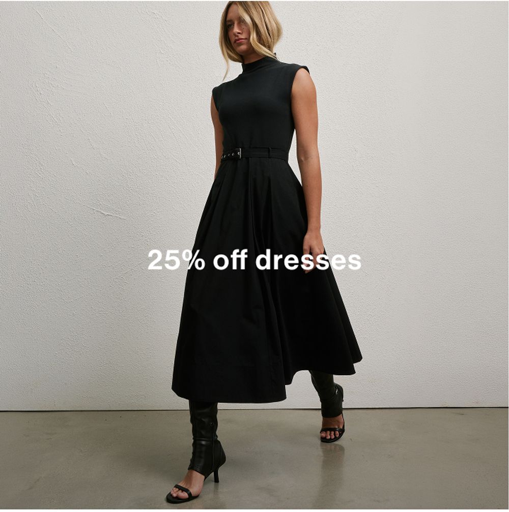 Woman posing in front of a white wall wearing a black dress with text that states "25% off dresses"