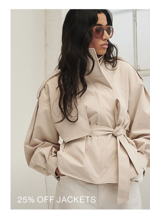 Woman wearing a almond trench looking to the side