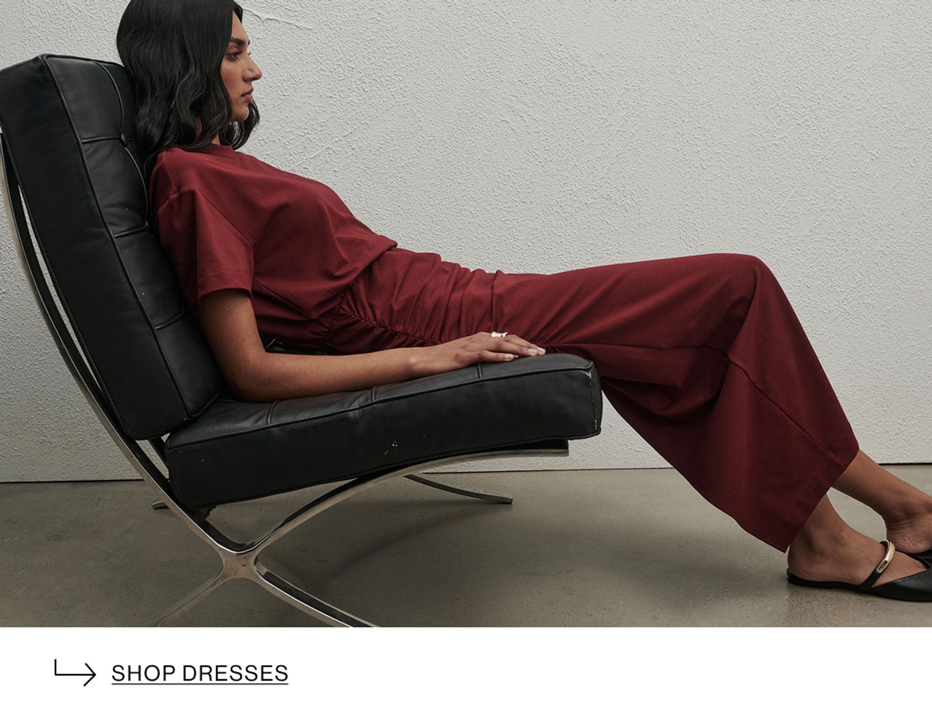 Woman wearing a brown top, and sunglasses. Text reads "shop tops & tees"