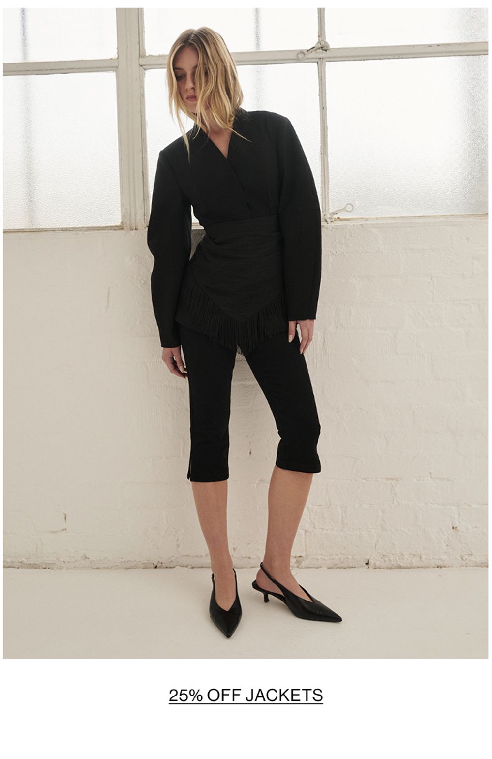 Woman posing is black barrel blazer with text that states shop jackets