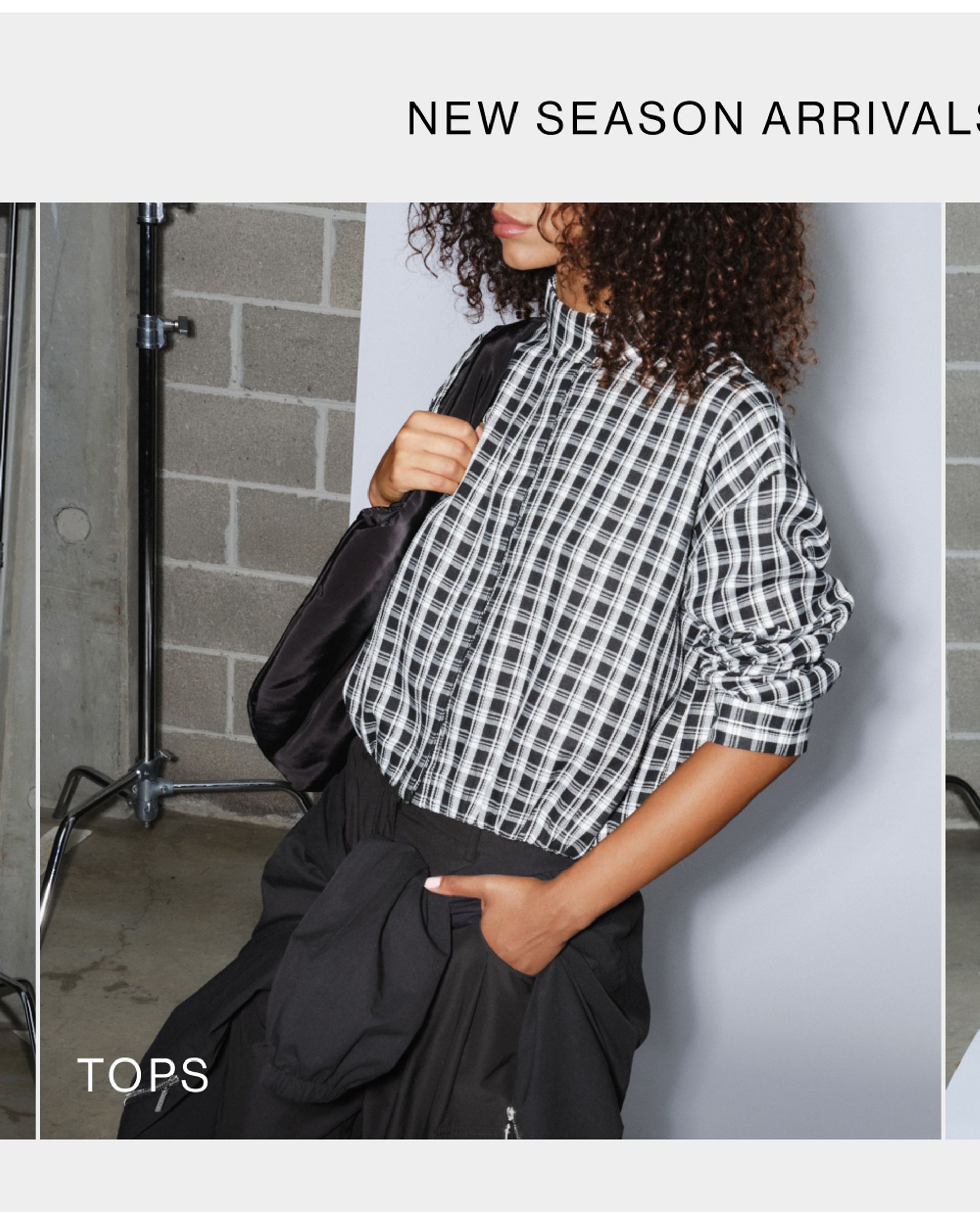 Woman posing with her hand in her pocket with a checkered jacket on with text that reads "tops"