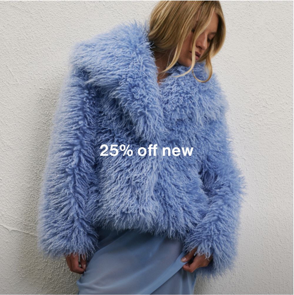 Woman standing in front of a white wall wearing a blue fluffy coat and blue skirt with text that reads "25% off new"