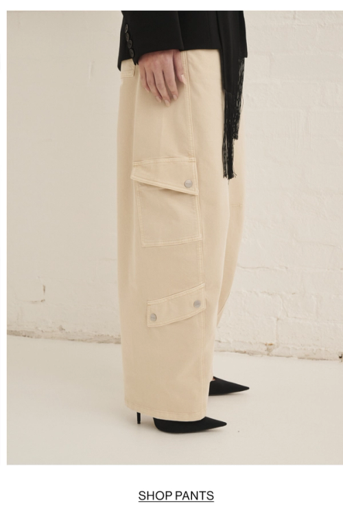 Woman posing in almond colour pants with text overlay shop pants