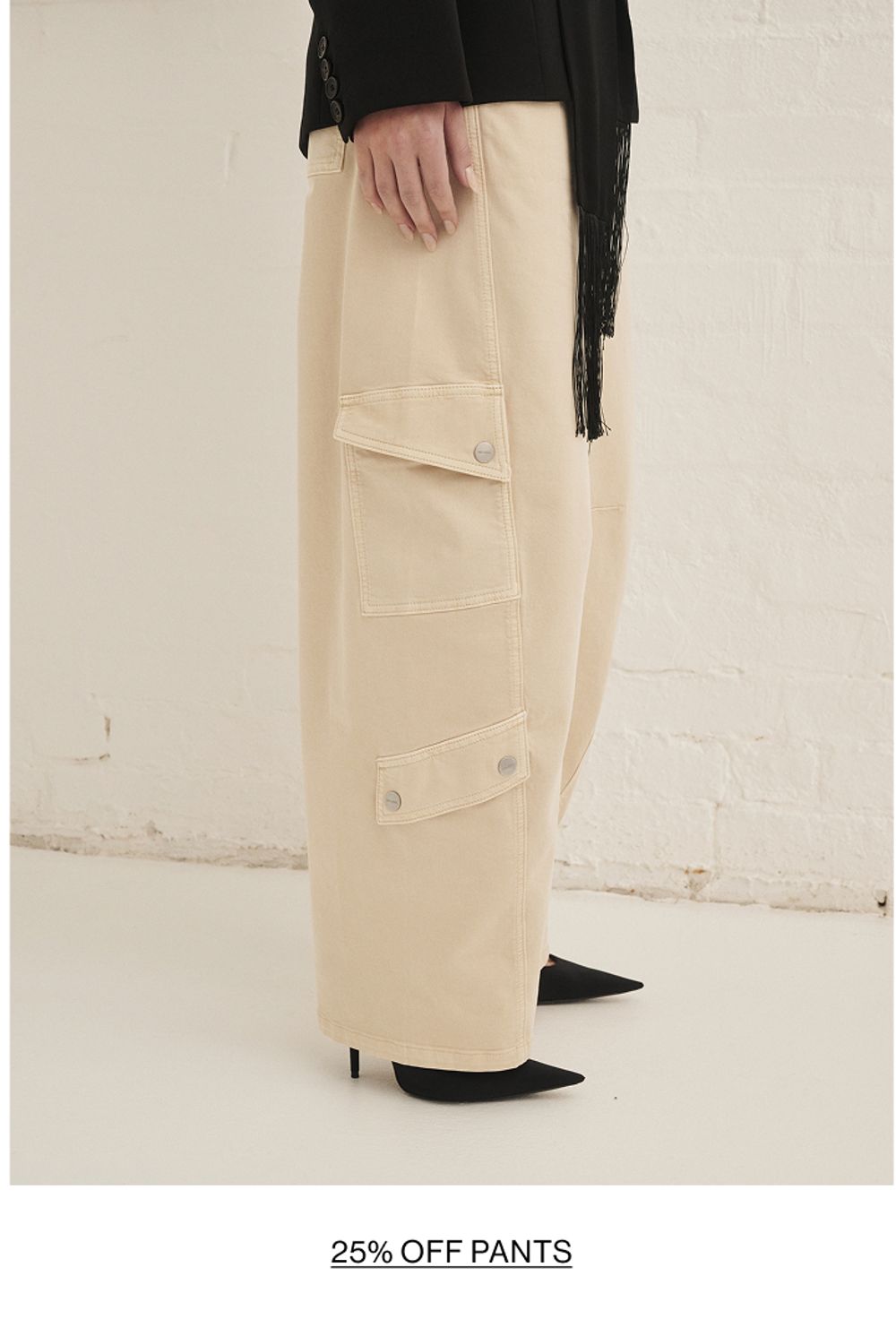 Woman posing in almond colour pants with text overlay shop pants