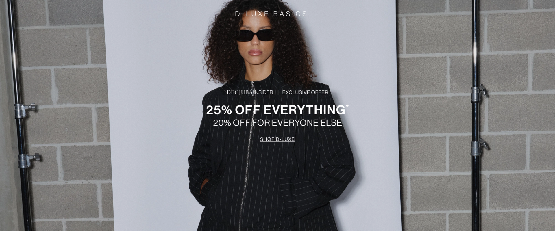 Model in a brown jacket standing in front of a white wall with text overlay which states new