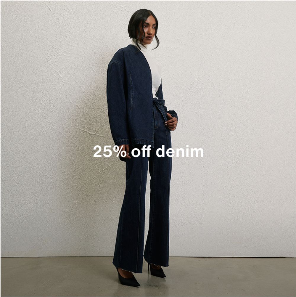 Woman posing in front of a white wall wearing a long sleeve denim set with text overlay which states "25% off denim"