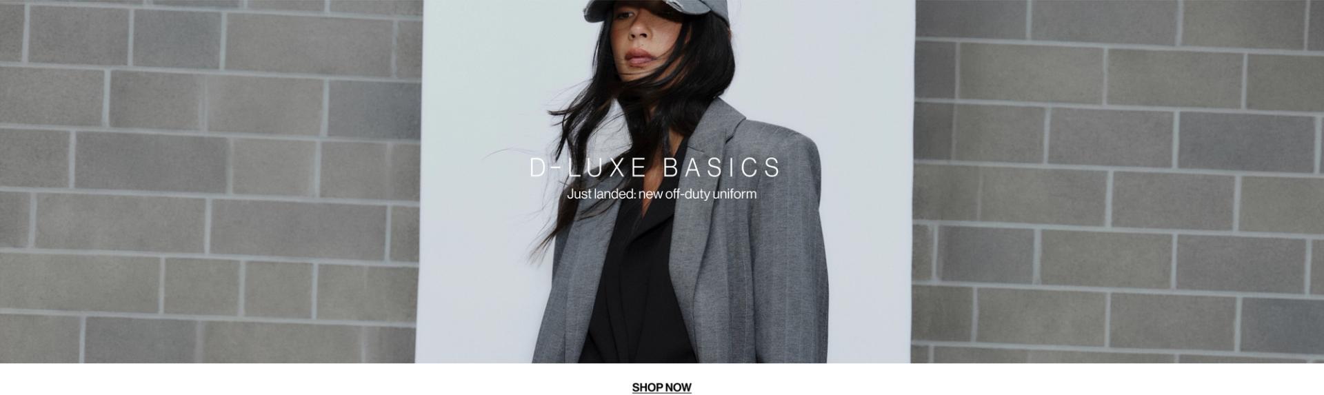 Model in a leather jacket standing in front of a white wall with text overlay which states "20% OFF DLUXE BASICS"