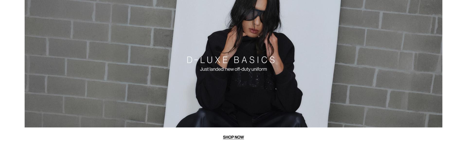 Model in a leather jacket standing in front of a white wall with text overlay which states "20% OFF DLUXE BASICS"