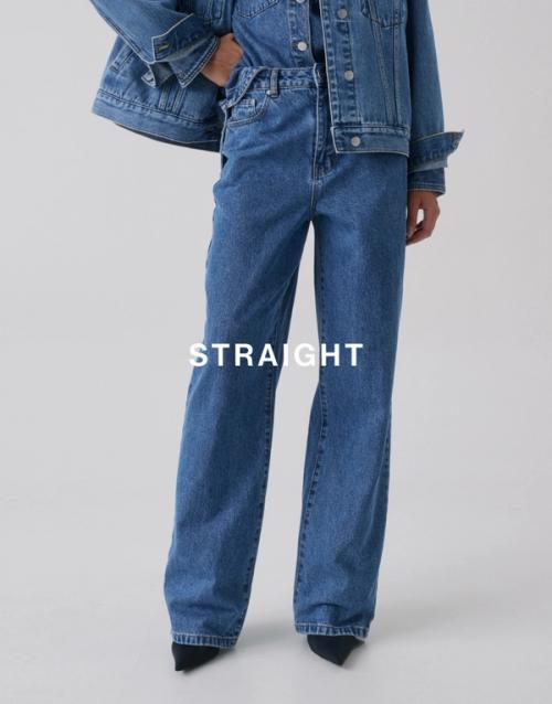 Model standing with one hand on her hip, wearing a matching denim set which has text overlay straight