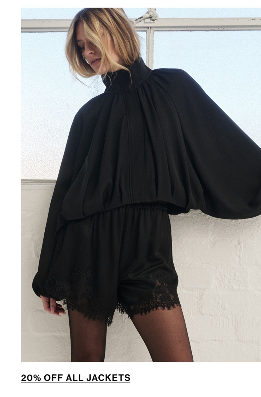 Woman standing in a black funnel neck jacket