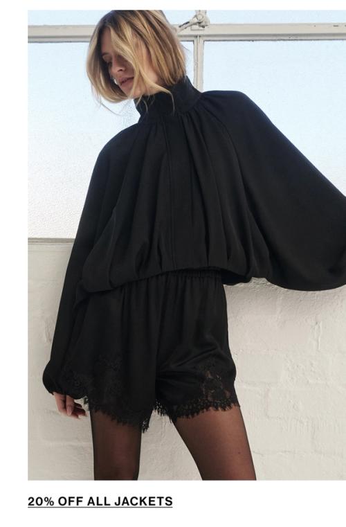 Woman standing in a black funnel neck jacket