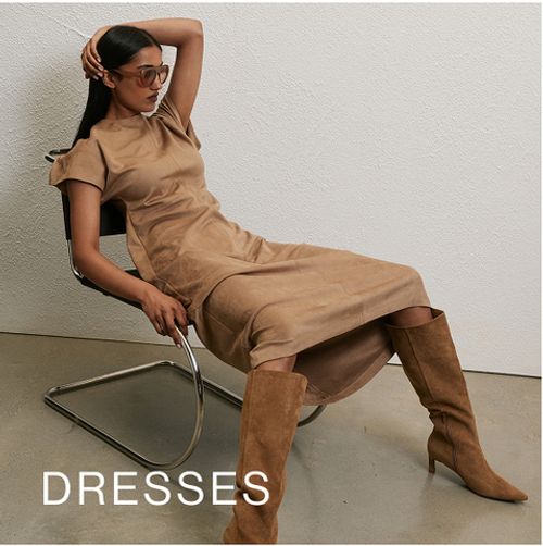 Woman standing in front of a white wall with text that reads "25% off jackets"