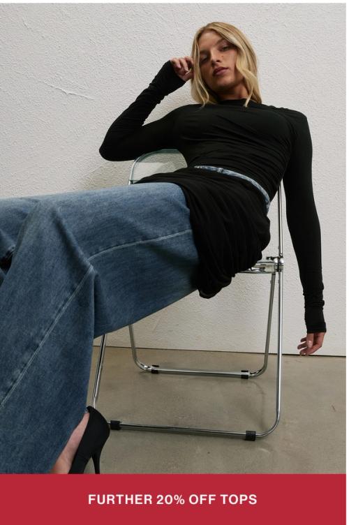 Model wearing black long sleeve top. SHOP FURTHER 20% OFF TOPS.