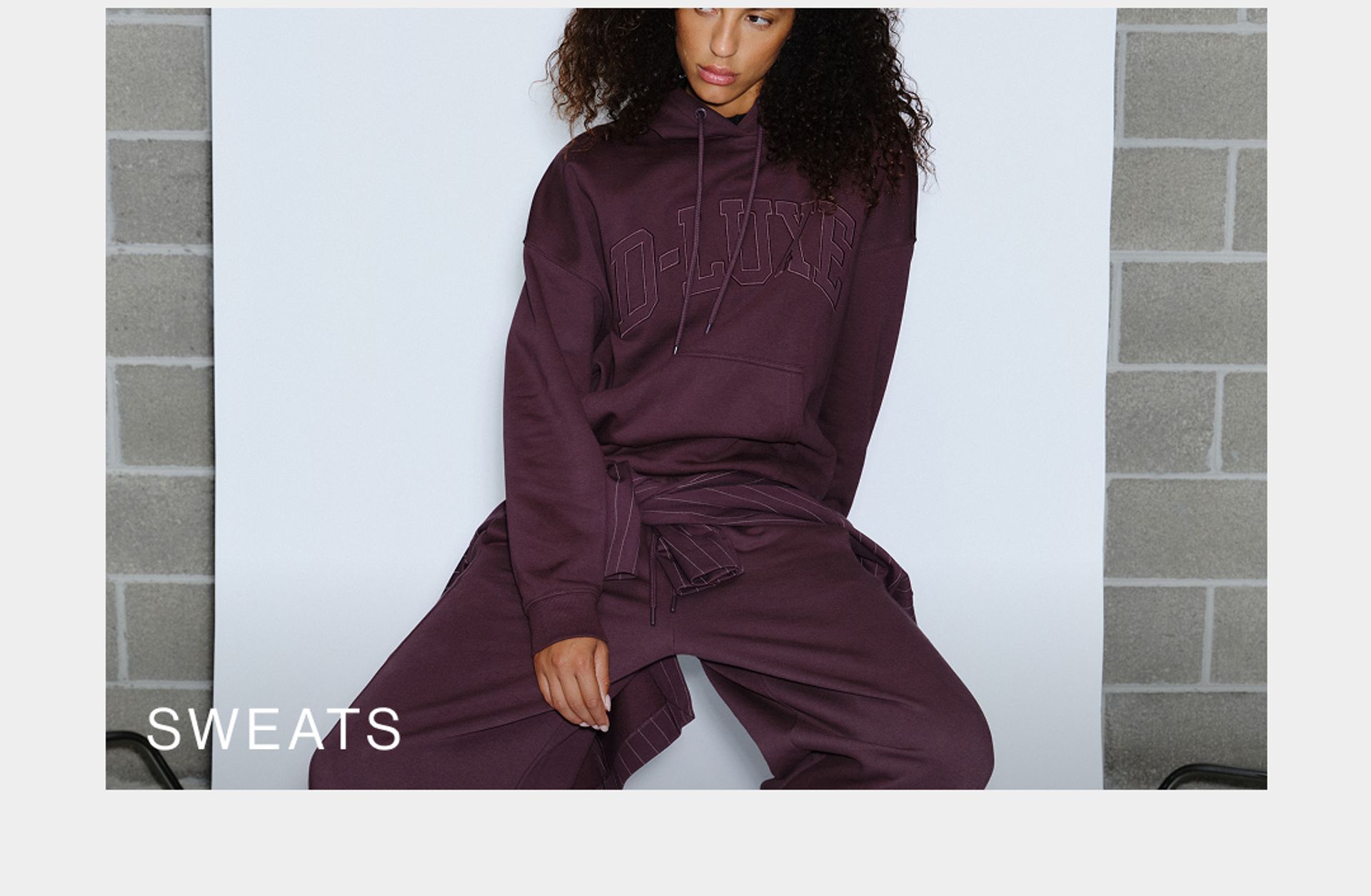 Model wearing a sweat set in midnight cherry in studio. SHOP D-LUXE SWEATS.