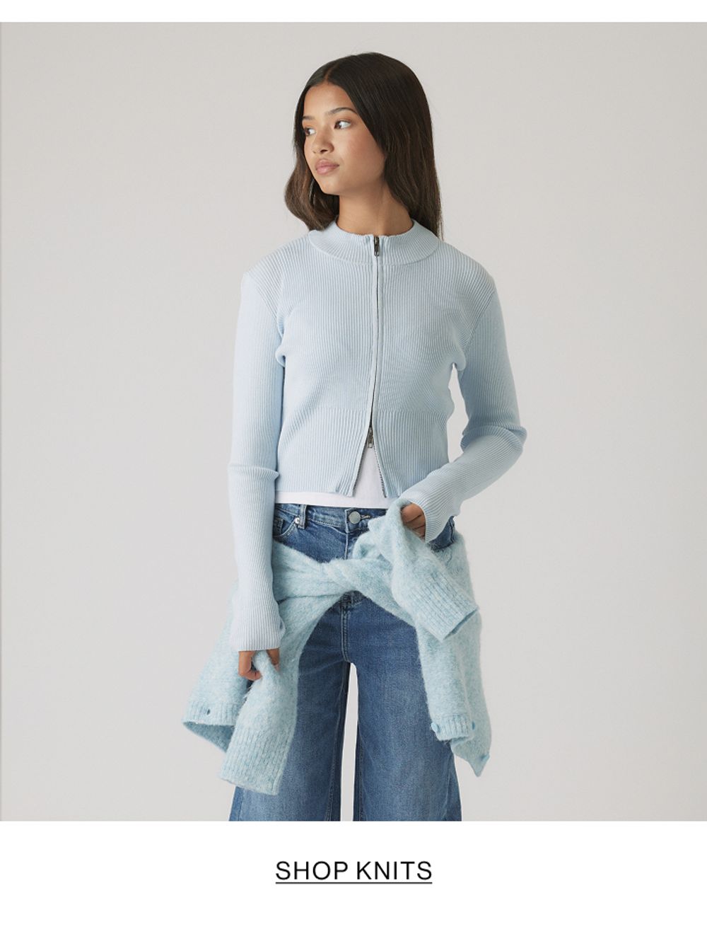 Girl in pale blue knit sweater and jeans – Kids Shop Knits.