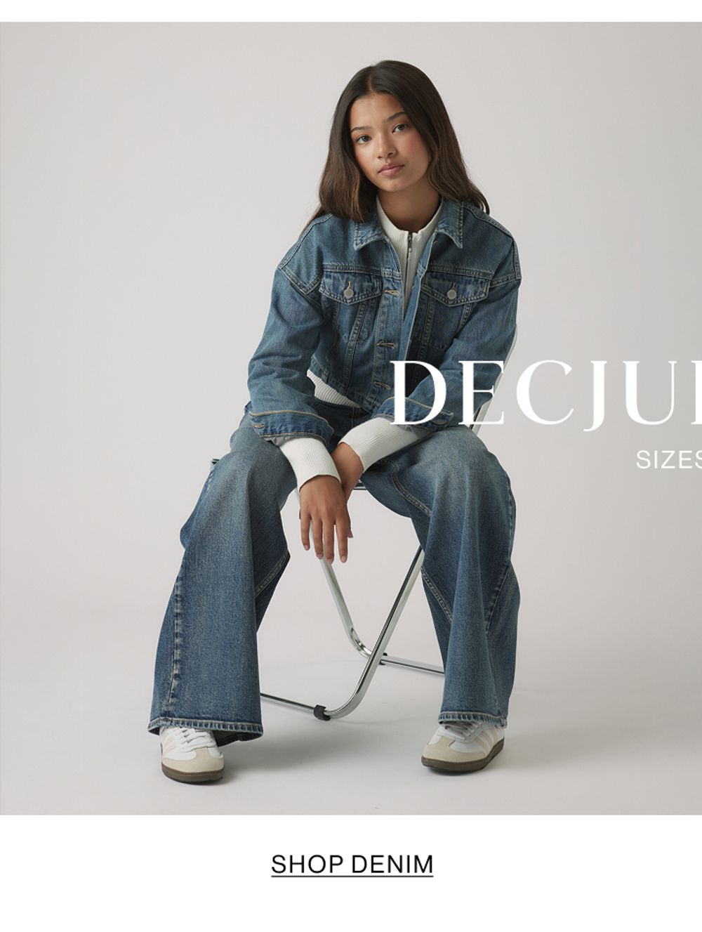 Girl seated in denim jacket and flared jeans – Kids Shop Denim.