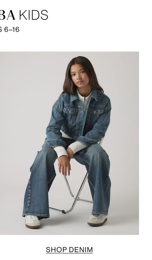 Girl seated in denim jacket and flared jeans – Kids Shop Denim.