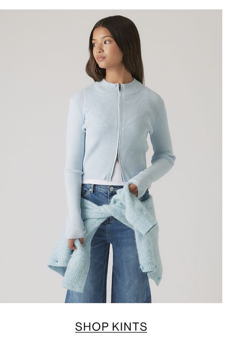 Girl in pale blue knit sweater and jeans – Kids Shop Knits.