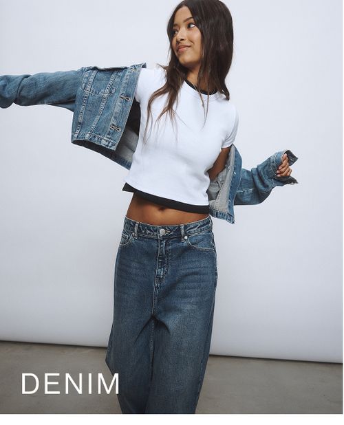 Young girl wearing a denim jacket and denim jeans against a neutral background. SHOP TEEN DENIM.