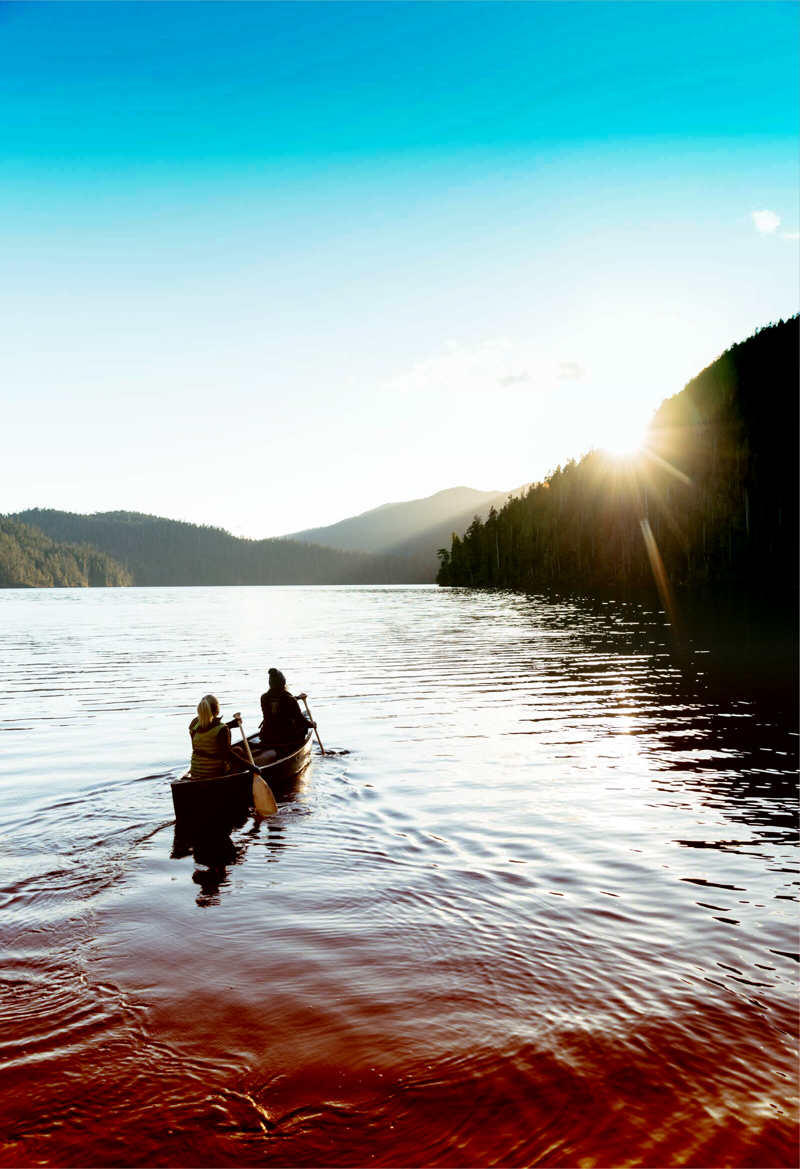 People canoeing on reflective water.