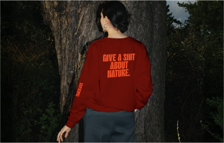 Person wearing a Trailblazer sweatshirt in a forest.