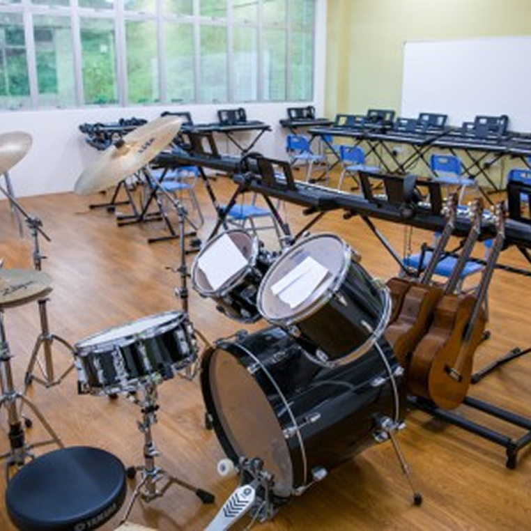 Invictus International School Malaysia Spring Hills Campus music classroom with drum kit, guitars, and keyboards