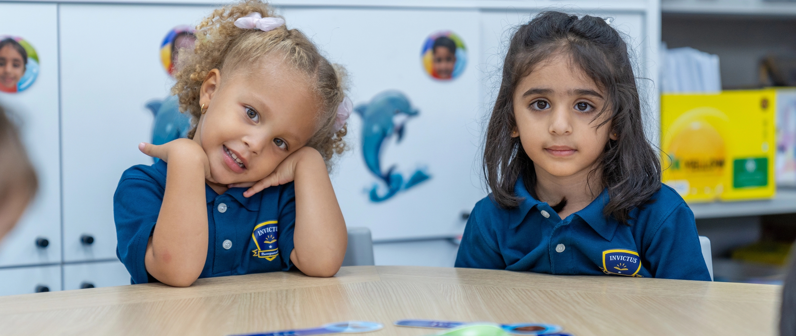 Two early years students smiling at the camera
