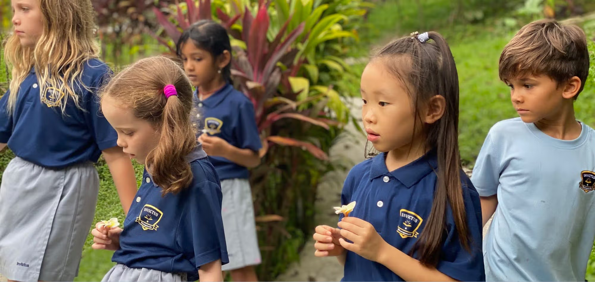 Invictus International School Singapore students exploring nature outdoors in school uniforms, engaging in hands-on learning and observation during an ECA activity.