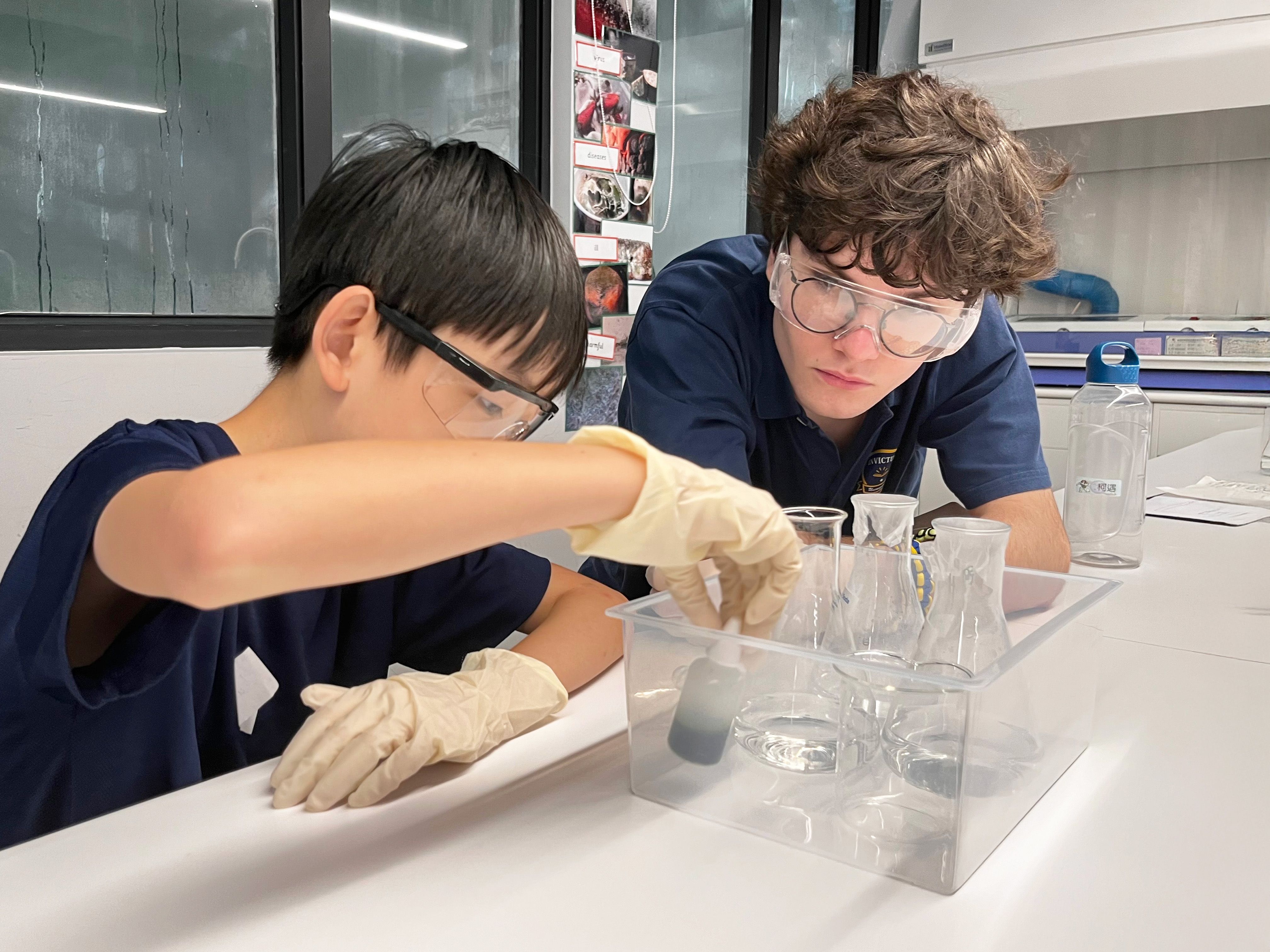 A teacher holding a paper, reviewing work with a secondary student