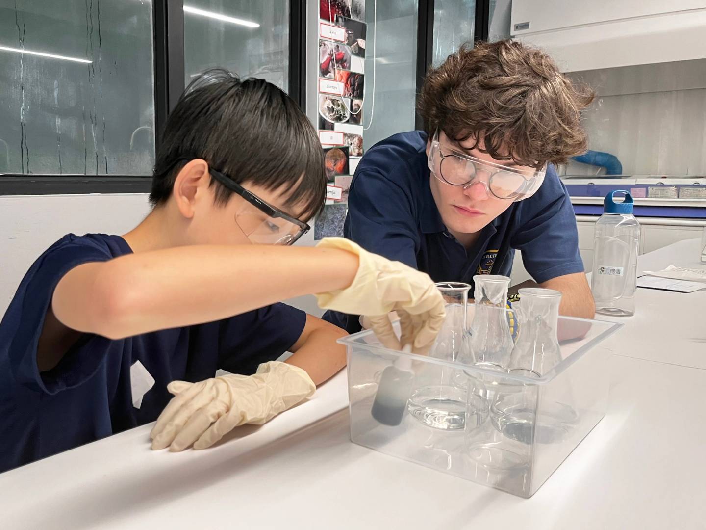 A teacher holding a paper, reviewing work with a secondary student