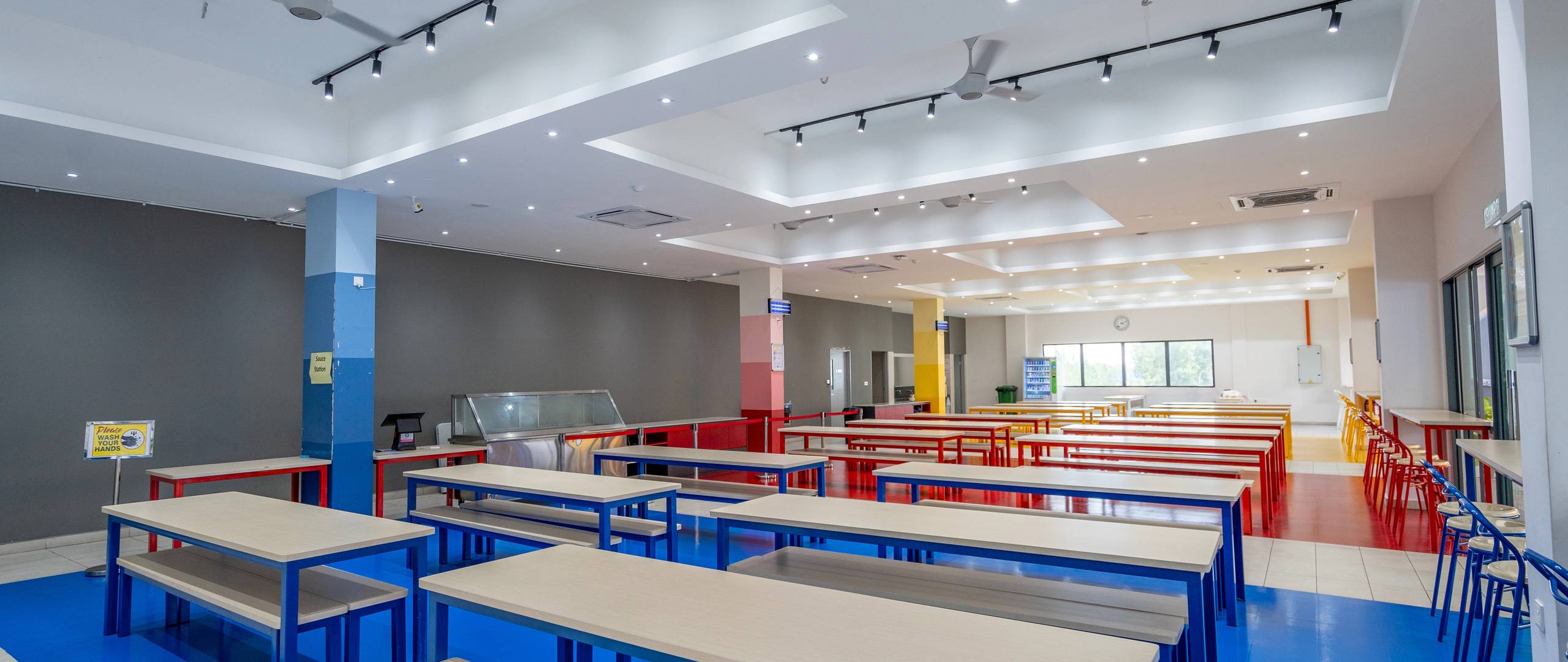 School canteen with colourful benches and bright open layout.