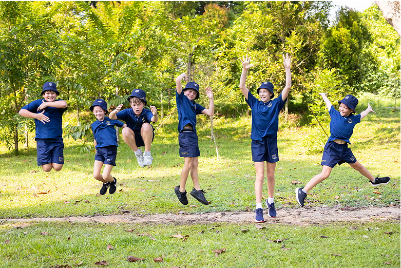 Happy Invictus students jumping in unison during an outdoor activity, showcasing energy, unity, and enthusiasm.
