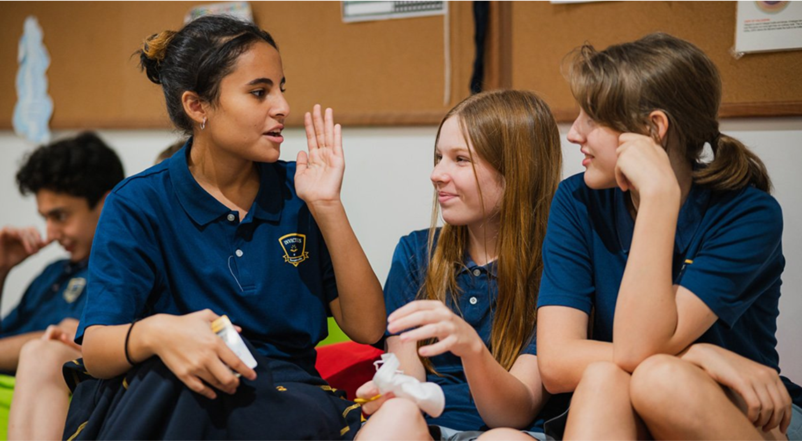 Secondary students at Invictus Bukit Timah interacting during a relaxed classroom break.