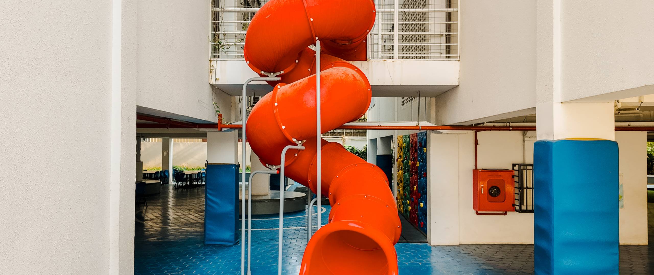 Playground slide area at Invictus Phnom Penh featuring a bright red spiral slide for students’ recreational play.