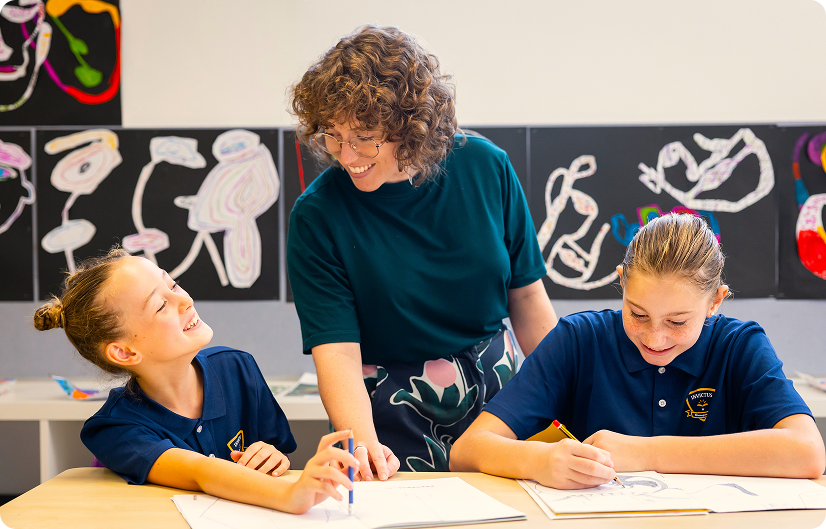 Art teacher engaging with two students during a drawing activity at Invictus Bukit Timah.