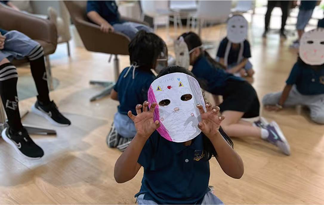 Students participating in a creative arts session wearing self-made masks, showcasing imagination, expression, and hands-on learning in the arts.